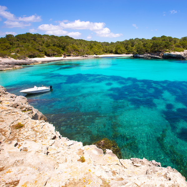 boat bobbing on the sea at Cala Turqueta beach on menorca island