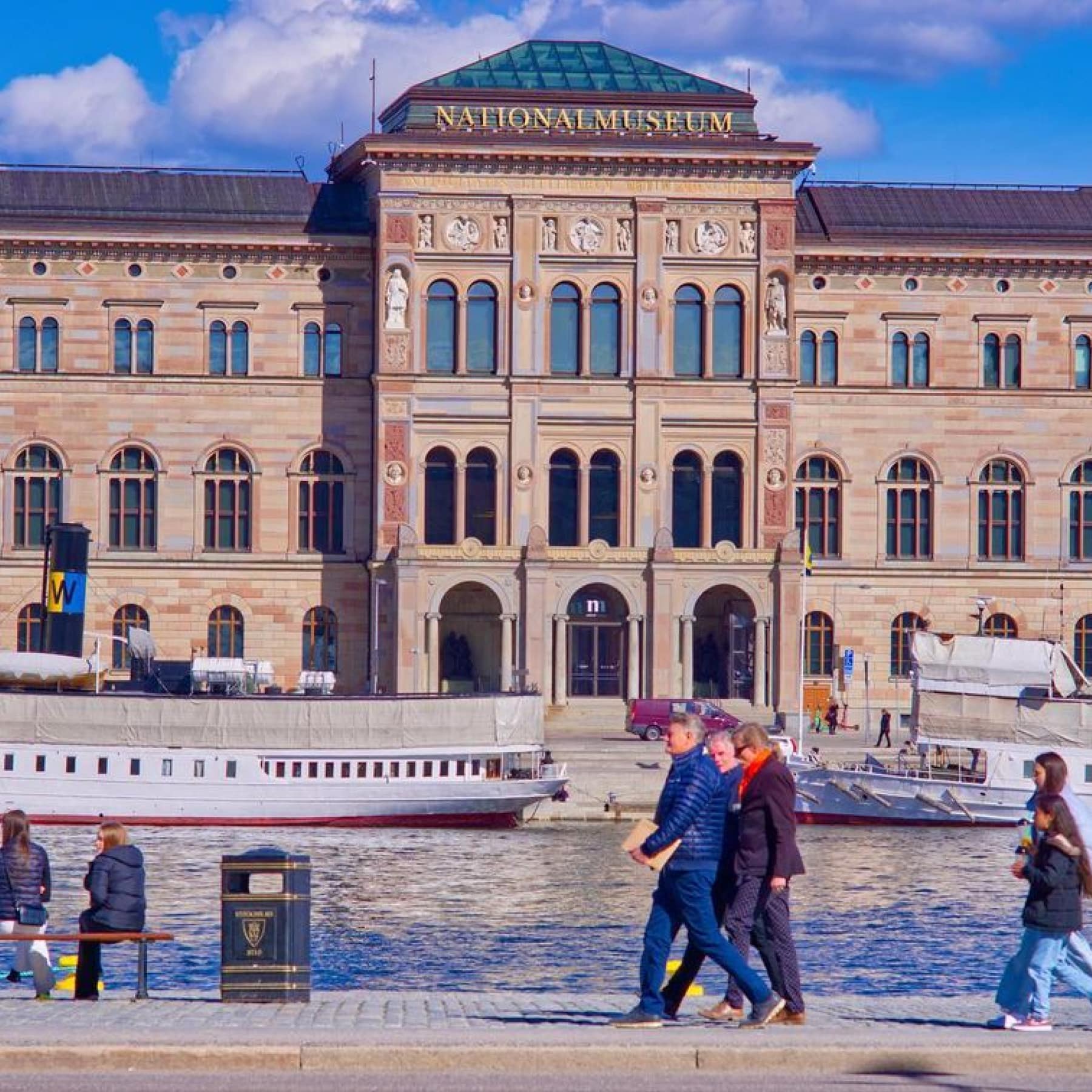 People walk along the river outside the Nationalmuseum in Stockholm